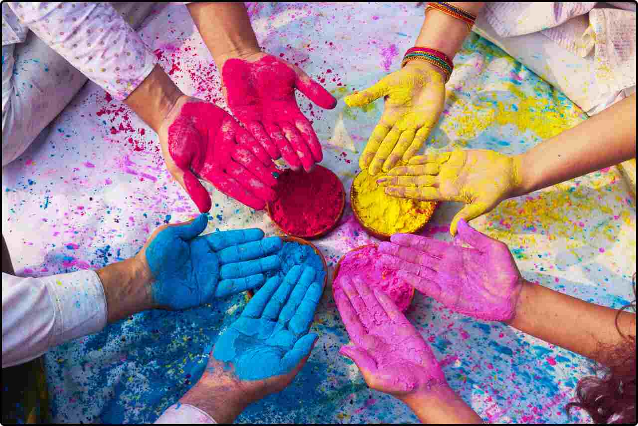 Colorful Holi powder sprinkled on hands, ready for festive celebrations.